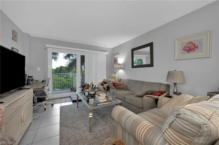 Living room with light tile patterned floors and an office area