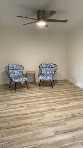 Sitting room with ceiling fan and light wood-type flooring