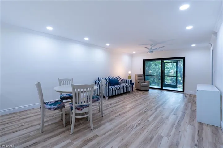Living room with ornamental molding, ceiling fan, and light hardwood / wood-style floors