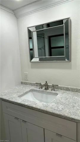 Bathroom featuring ornamental molding and vanity
