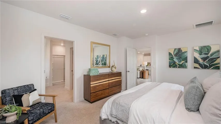 Bedroom with light carpet, ensuite bathroom, recessed lighting, and light tile patterned floors