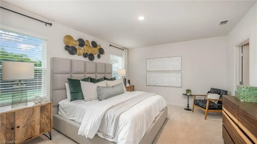 Bedroom featuring light carpet and baseboards