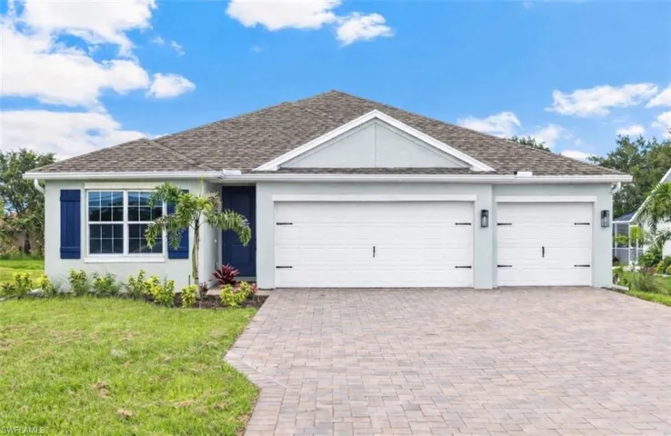 Single story home with stucco siding, a garage, decorative driveway, and a front yard