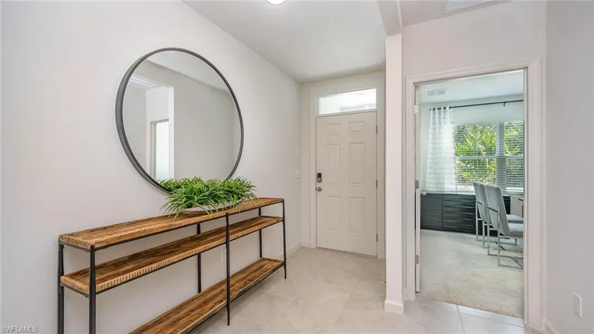 Foyer featuring light tile patterned flooring and baseboards