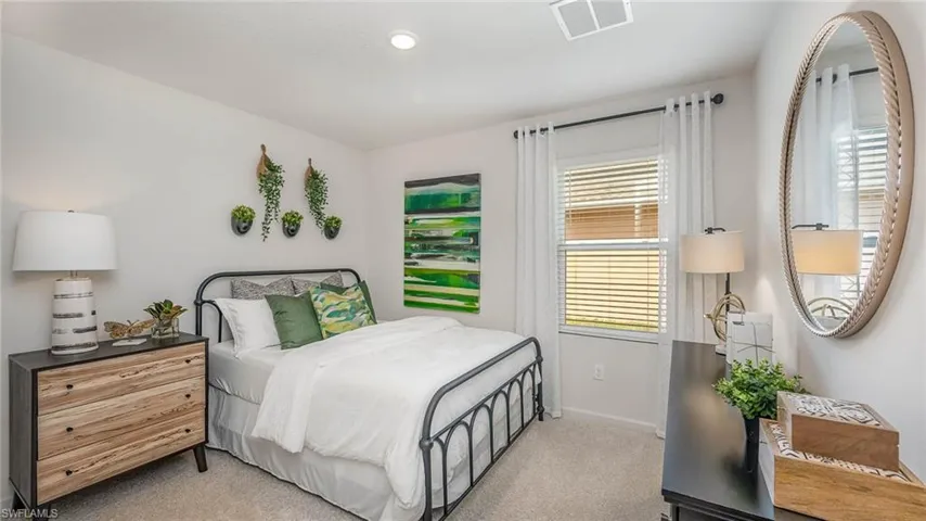 Bedroom featuring light carpet and baseboards