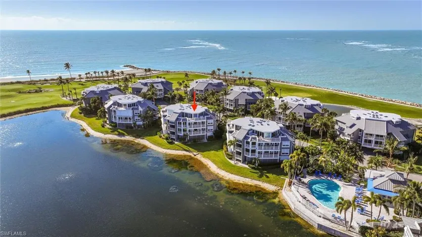 Drone / aerial view of a nearby body of water and a golf course