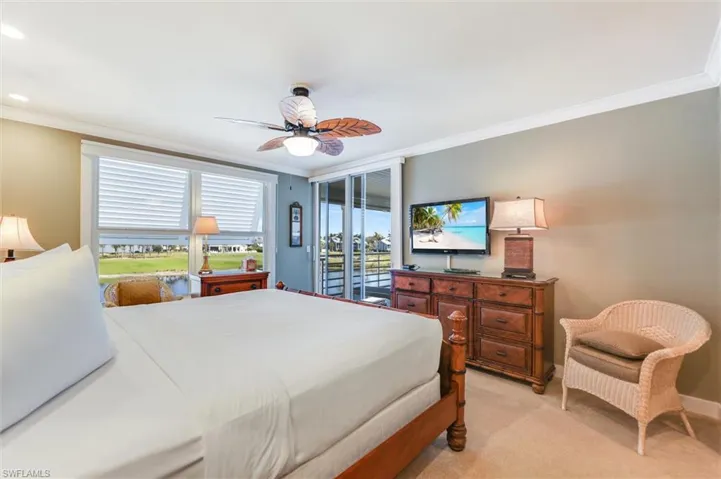 Bedroom with ornamental molding, light carpet, access to outside, and a ceiling fan
