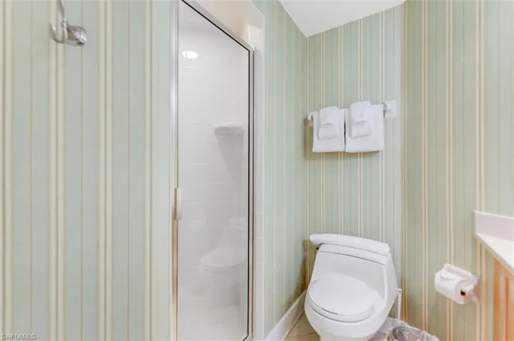 Full bathroom with toilet and a shower stall
