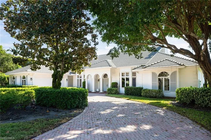 View of front of house featuring decorative driveway, stucco siding, and a tiled roof