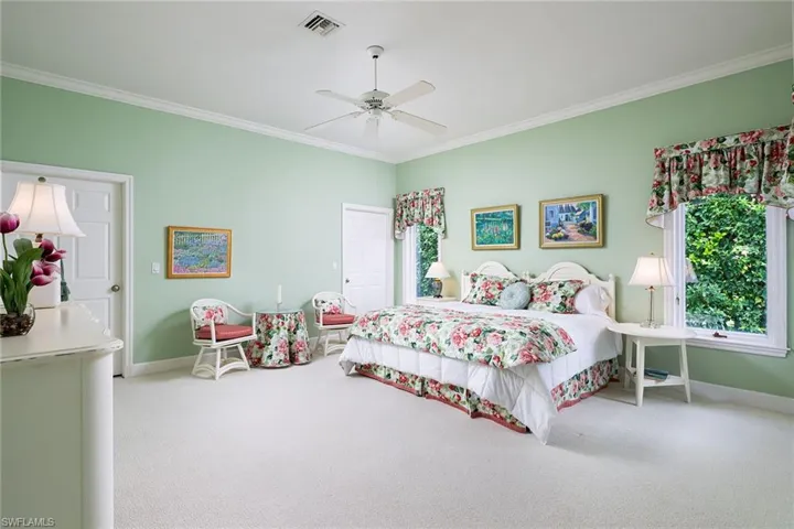 Bedroom featuring carpet, ornamental molding, and a ceiling fan