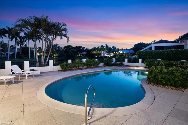 Pool at dusk featuring a fenced backyard and a patio area