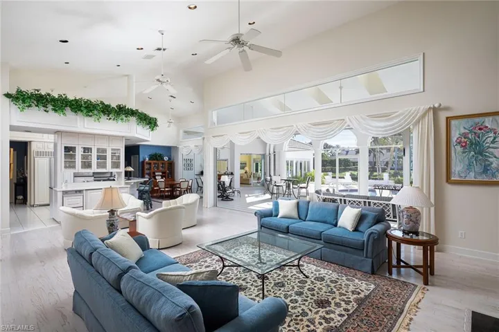 Living room featuring a ceiling fan, high vaulted ceiling, and light wood finished floors