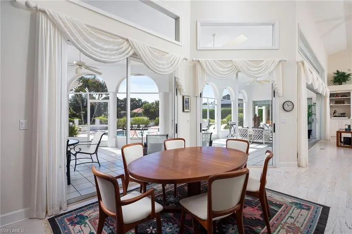 Dining area featuring a high ceiling, light wood-style flooring, and ceiling fan