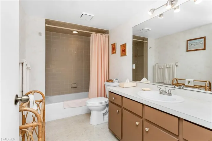 Bathroom featuring vanity and shower / bath combination with curtain