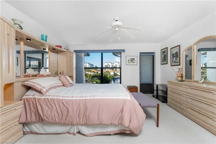 Carpeted bedroom with ceiling fan and a textured ceiling