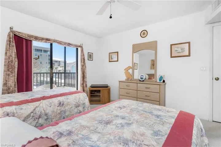 Carpeted bedroom featuring access to outside and ceiling fan