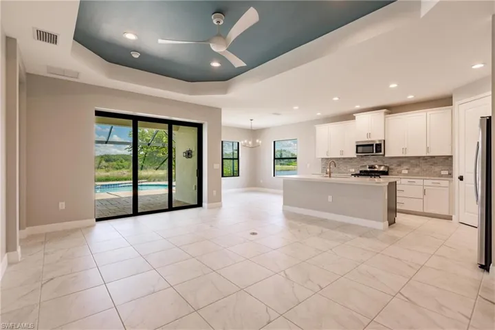 Large tile flooring, tray ceiling and open to the kitchen.
