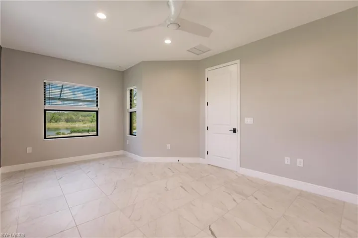 Primary bedroom with views of pool area and lake.