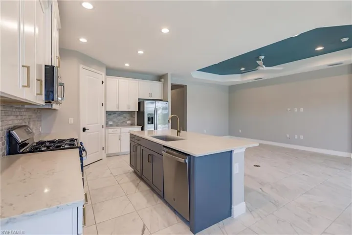 Bright white kitchen with contrasting chocolate cabinetry on island.