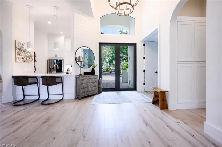 Washed with natural light entry appointed with designer lighting and impact glass front doors