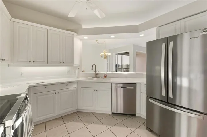 Kitchen with appliances with stainless steel finishes, white cabinets, a chandelier, light countertops, and recessed lighting