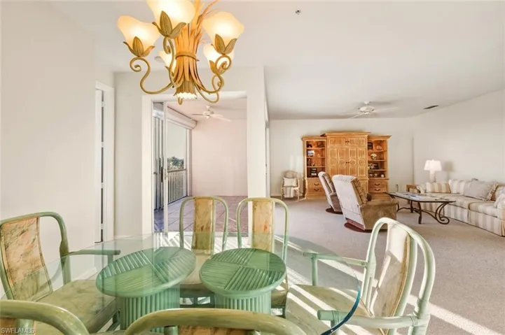 Dining room featuring a chandelier, carpet, and a ceiling fan