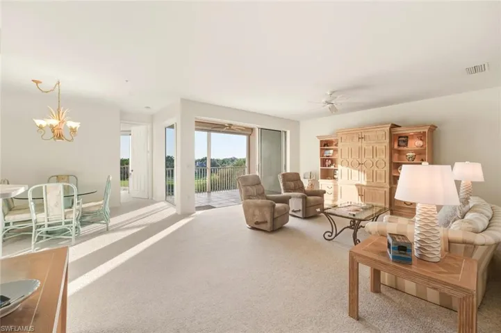 Living room with carpet flooring, a chandelier, and ceiling fan
