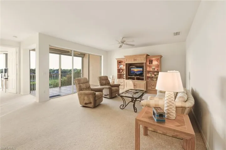 Living room with light carpet and a ceiling fan
