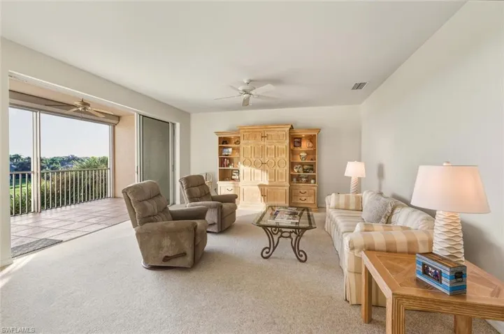 Living room with carpet and a ceiling fan