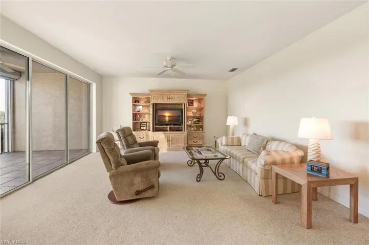 Living area with light carpet and a ceiling fan