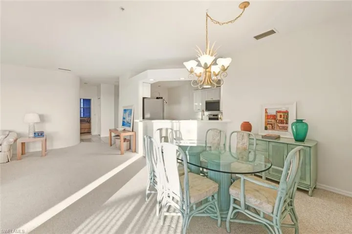 Carpeted dining space with a chandelier