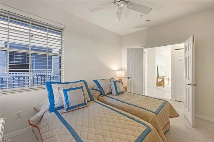 Carpeted bedroom featuring baseboards and a ceiling fan