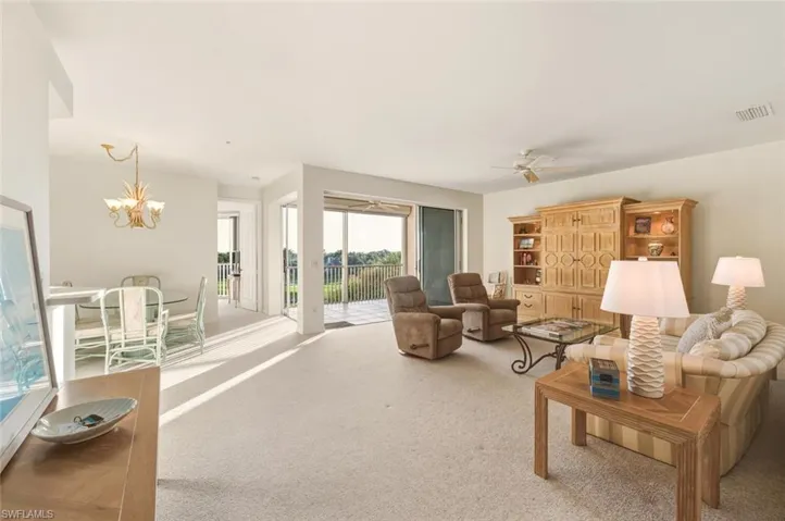 Carpeted living room with a ceiling fan and a chandelier