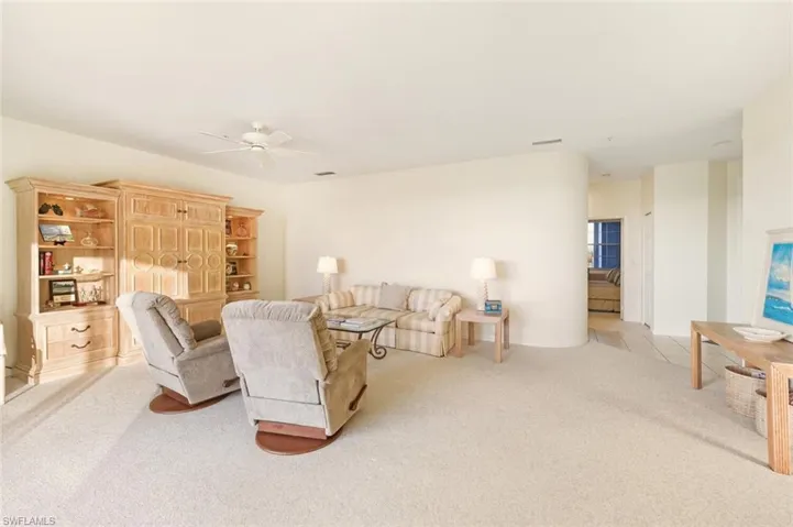 Living area featuring light carpet and ceiling fan