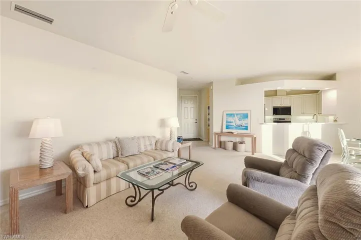 Carpeted living room featuring a ceiling fan