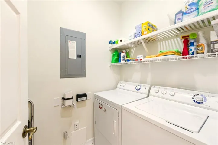 Laundry room with electric panel and separate washer and dryer