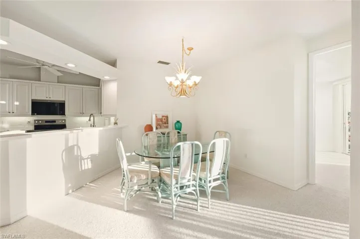 Dining area featuring light colored carpet, a chandelier, and recessed lighting