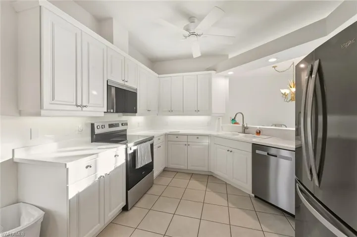 Kitchen featuring stainless steel appliances, light countertops, a chandelier, light tile patterned floors, and recessed lighting