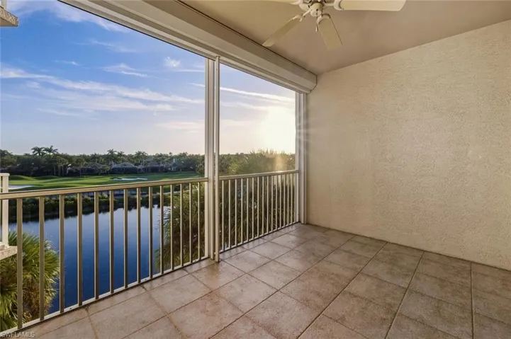 Balcony featuring a water view, a ceiling fan, golf course view, and a sunroom