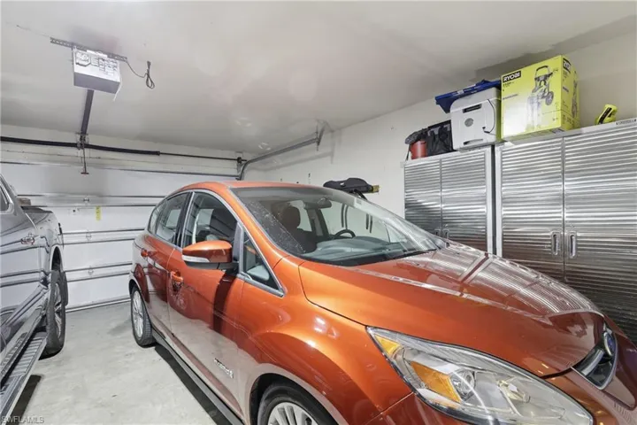 Garage featuring a garage door opener and storage.