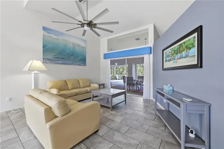 Living room with a sliding glass doors to screened pool lanai.