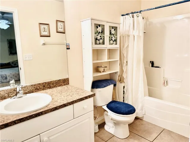 Full bath featuring light tile patterned flooring, vanity, and shower / tub combo with curtain
