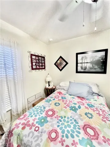 Bedroom with a textured ceiling and ceiling fan
