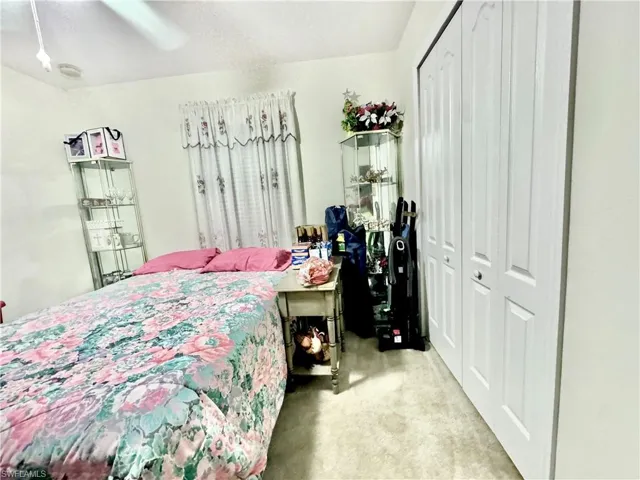 Bedroom featuring a closet, light carpet, and ceiling fan