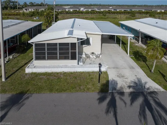 View of property featuring driveway, a carport, and a residential view