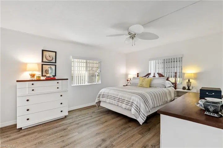 Bedroom featuring multiple windows, light wood finished floors, and a ceiling fan