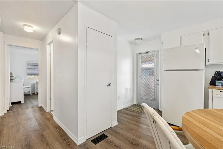 Kitchen featuring white appliances, white cabinetry, light and plenty of natural light
