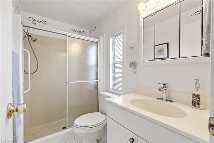 Full bath with vanity, a shower stall, and light tile patterned floors