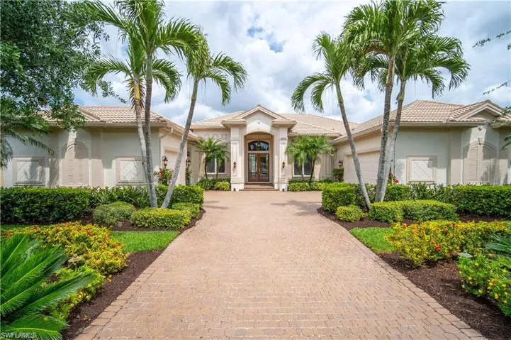 View of front facade with french doors, stucco siding, decorative driveway, and a garage