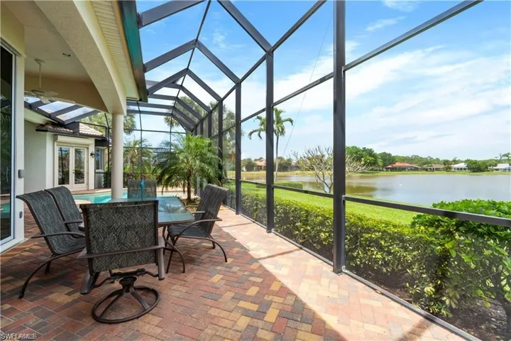 Sunroom / solarium with a patio area, outdoor dining space, a water view, french doors, and healthy amount of natural light